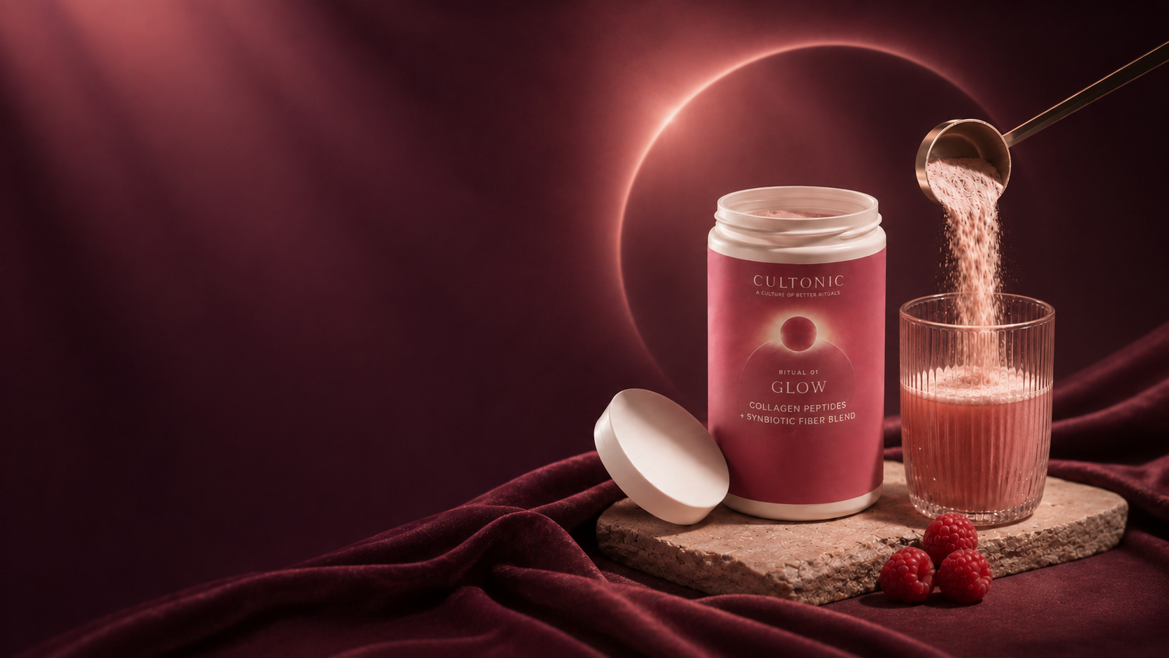 Open Cultonic Glow tub with a scoop pouring pink powder into a glass beside raspberries